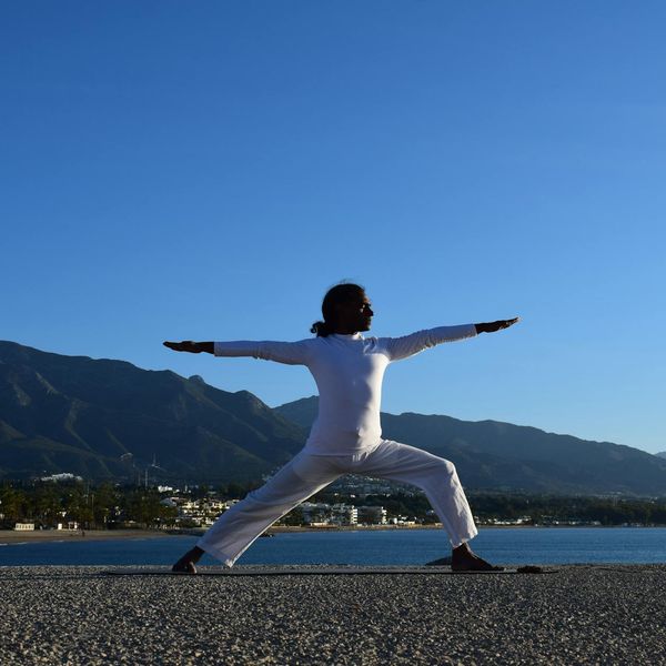 Silhouette of a person in a powerful yoga pose during sunrise.
